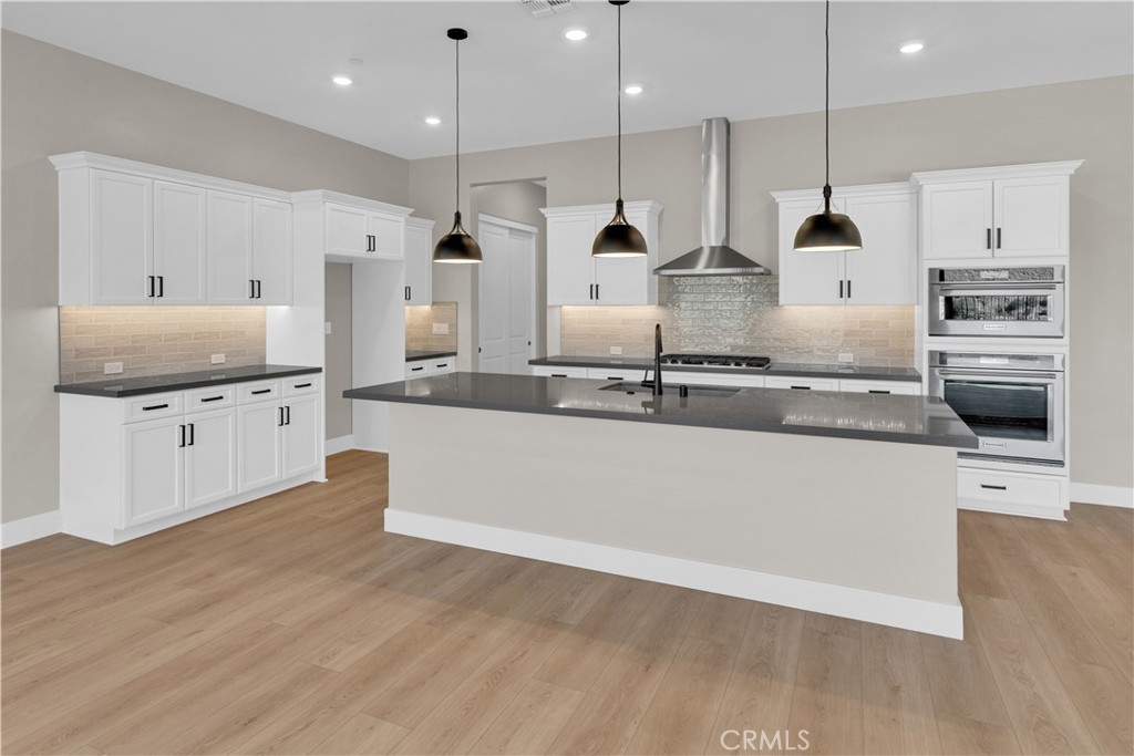 3731 Siembra Road Paso Robles, CA 93446 - Photo 2 of 21 a large kitchen with stainless steel appliances a large counter top a stove a sink and a wooden floors