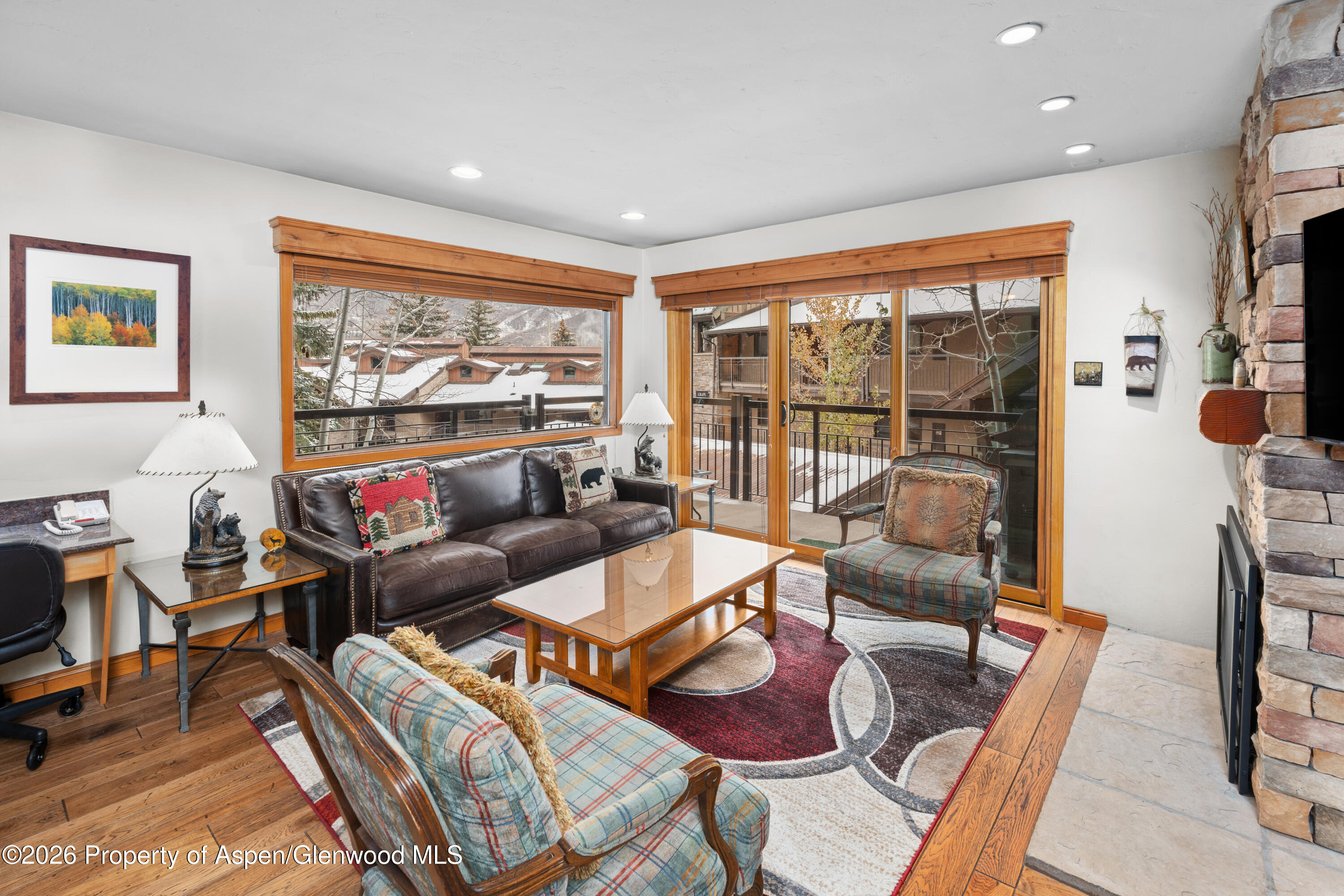 400 Wood Road, Unit 2111H Snowmass Village, CO 81615 - Photo 3 of 16 a living room with furniture a flat screen tv and a floor to ceiling window