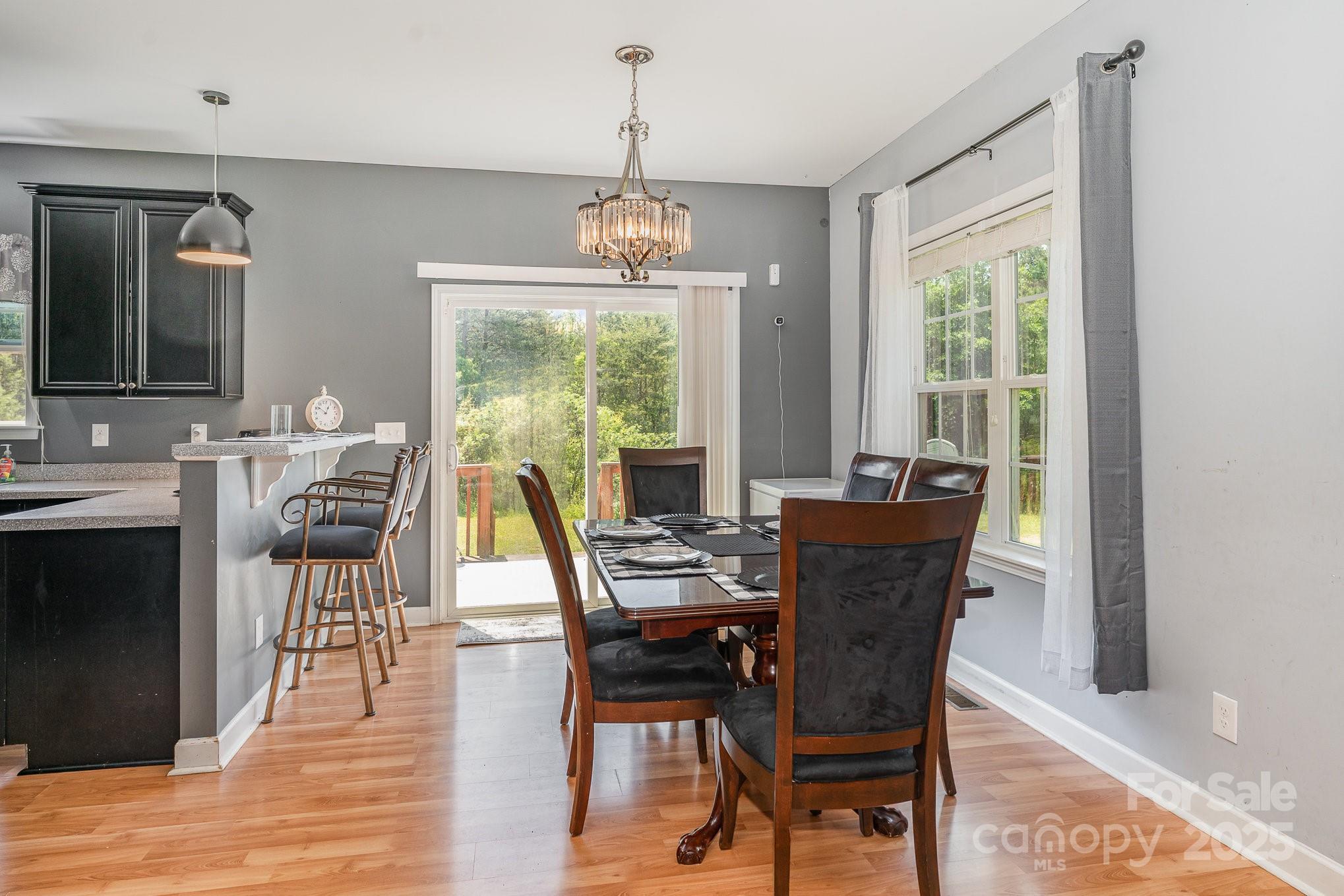 4242 Lake Ridge Court Ramseur, NC 27316 - Photo 15 of 33 a dining room with wooden floor a chandelier a wooden table and chairs