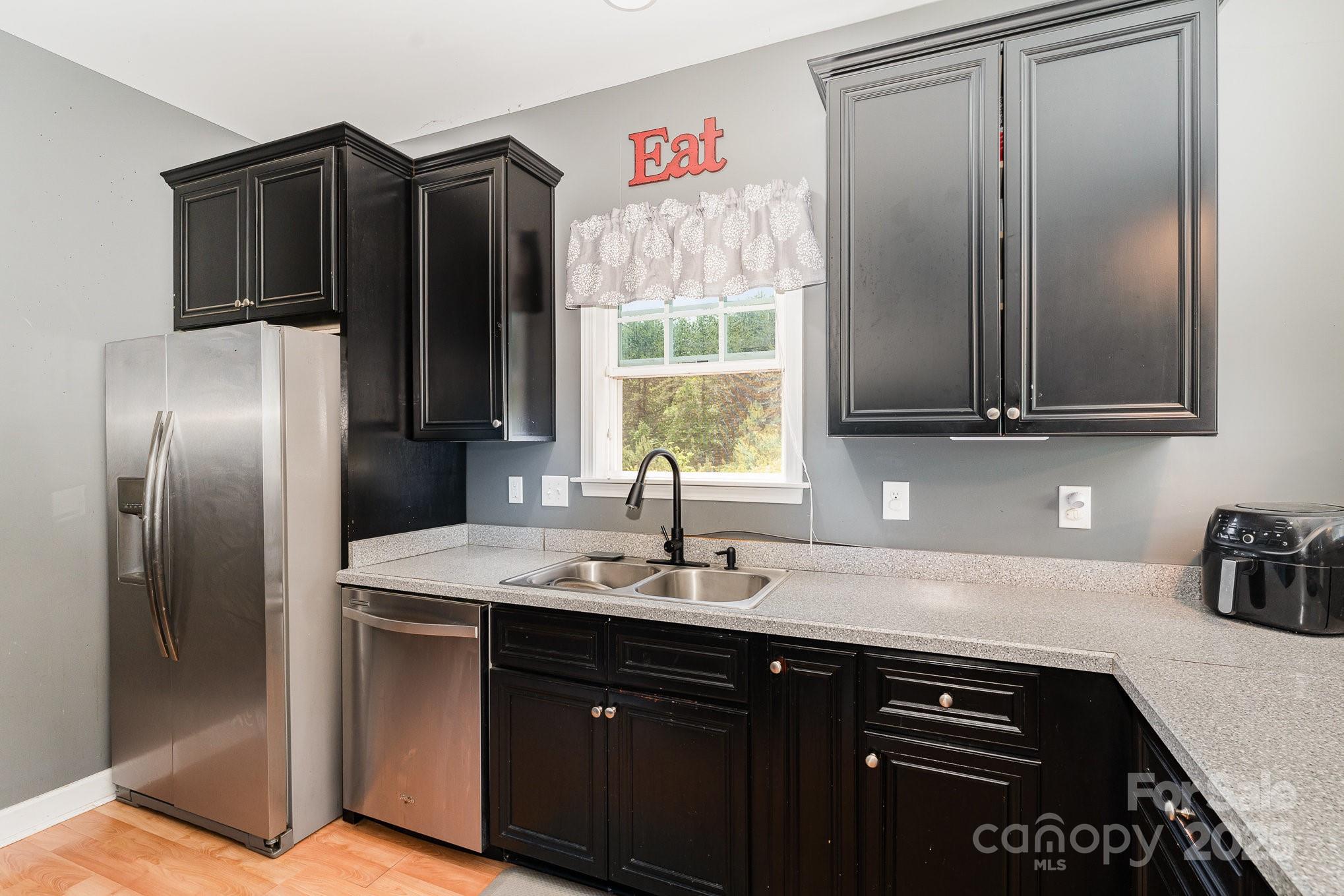 4242 Lake Ridge Court Ramseur, NC 27316 - Photo 18 of 33 a kitchen with stainless steel appliances granite countertop a refrigerator and a sink