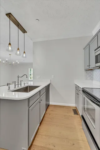 a kitchen with kitchen island granite countertop a sink stainless steel appliances and cabinets