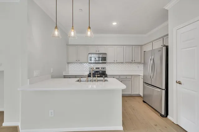 a kitchen with kitchen island a sink stainless steel appliances and cabinets