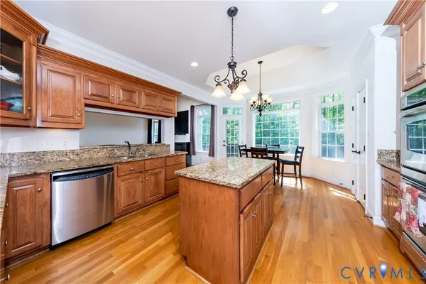a kitchen with stainless steel appliances granite countertop a sink a stove and a wooden floors