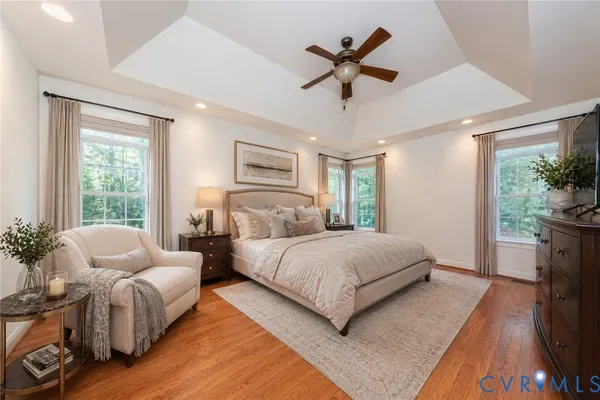 a spacious bedroom with a large bed a chandelier and a couch
