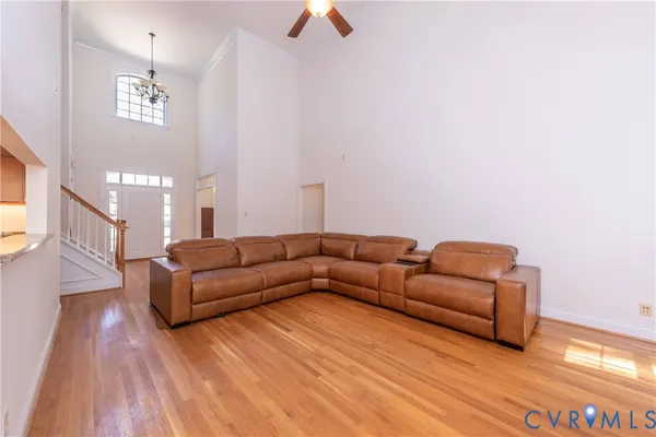 a living room with couches and a dining table with wooden floor