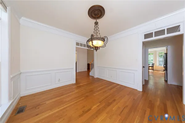 a view of a room with wooden floor and chandelier