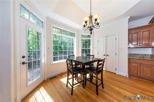 a view of a dining room with furniture a chandelier and wooden floor