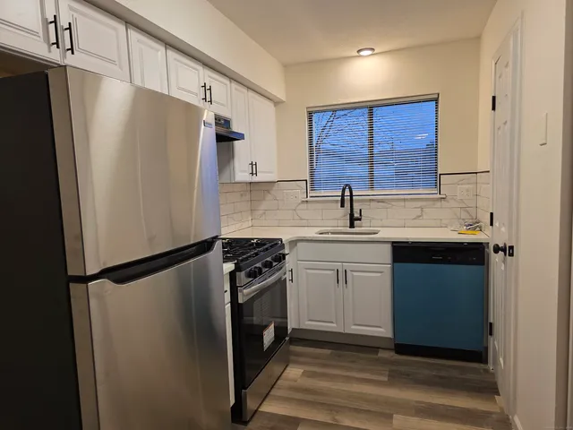 a kitchen with a refrigerator sink and cabinets