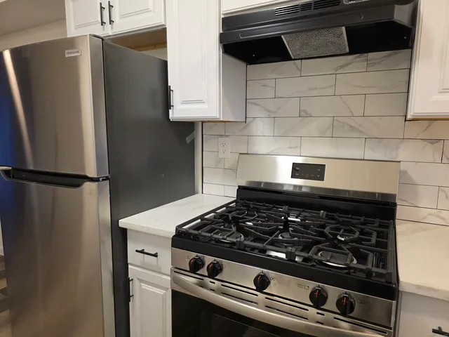 a stove top oven sitting inside of a kitchen