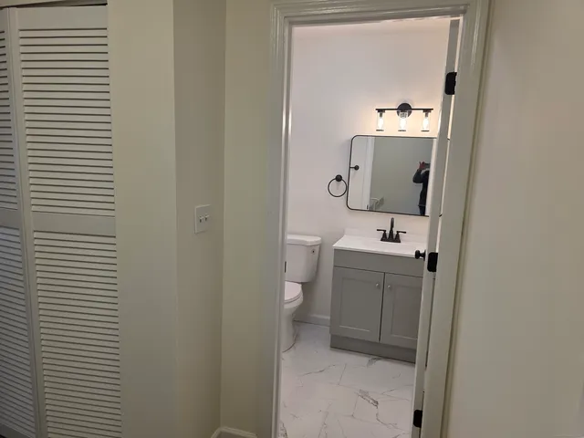 a bathroom with a toilet sink and mirror