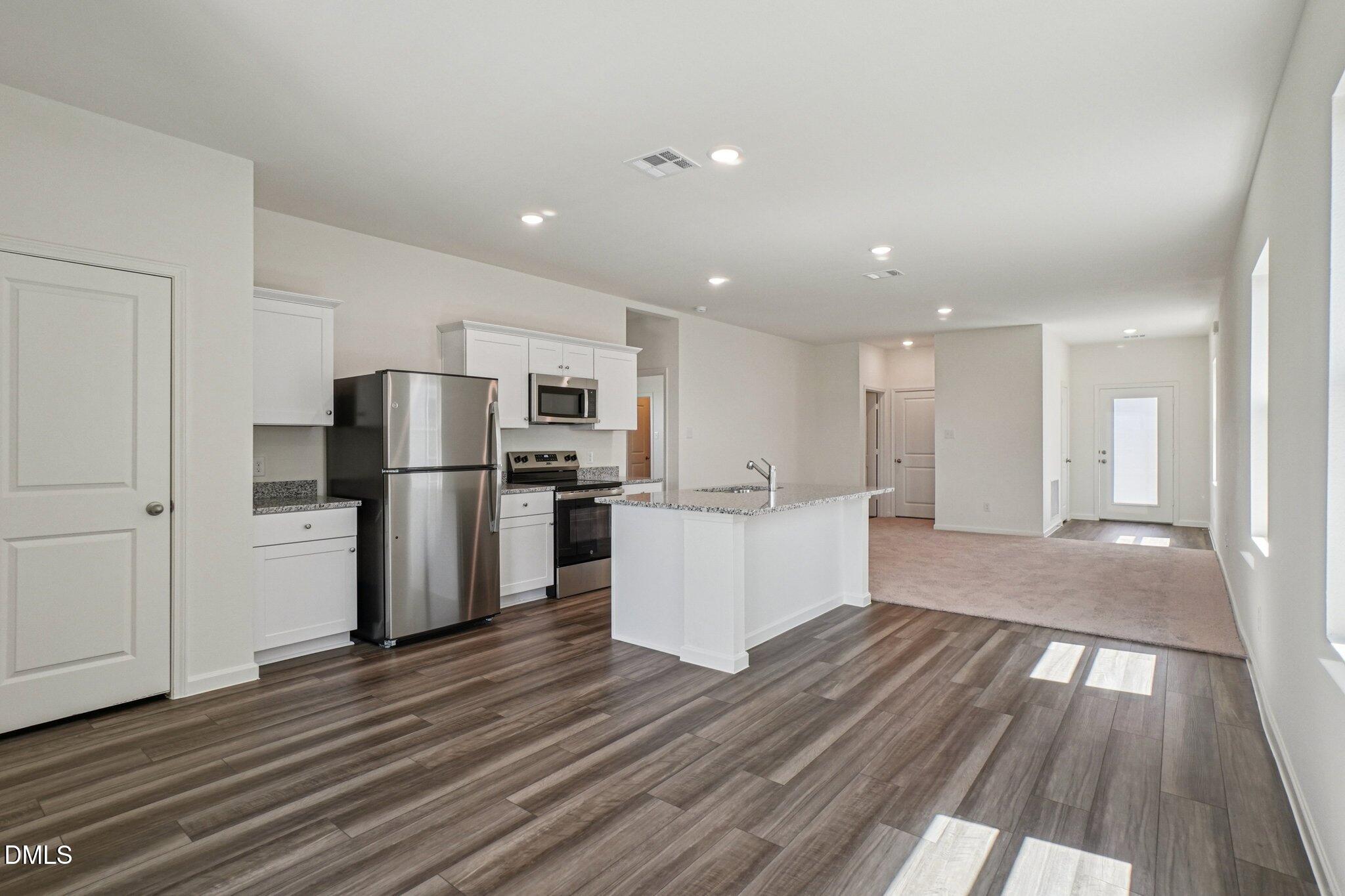 1316 Solace Way Rolesville, NC 27571 - Photo 10 of 29 a kitchen with a refrigerator and wooden floor