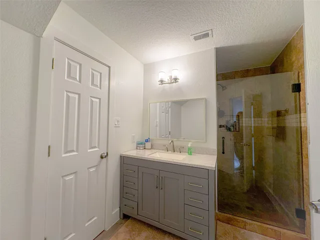a spacious bathroom with a shower sink and mirror