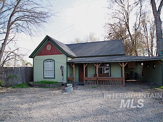 View of front of house with a porch, a carport, driveway, and roof with shingles