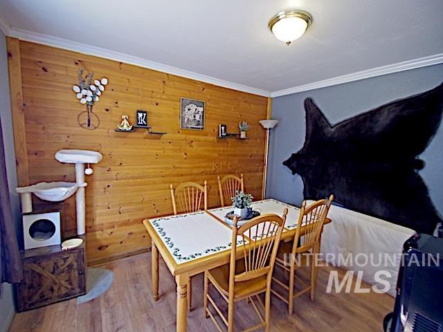 628 3rd Avenue South Payette, ID 83661 - Photo 16 of 19 Dining space with wooden walls, wood finished floors, and ornamental molding
