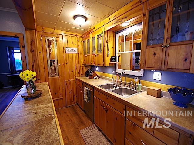 628 3rd Avenue South Payette, ID 83661 - Photo 6 of 19 Kitchen with wood finish cabinets, dark wood finished floors, stainless steel dishwasher, glass fronted cabinets, and wood walls