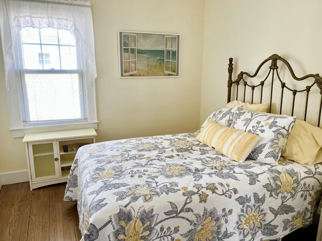 a bedroom with a bed and a large window