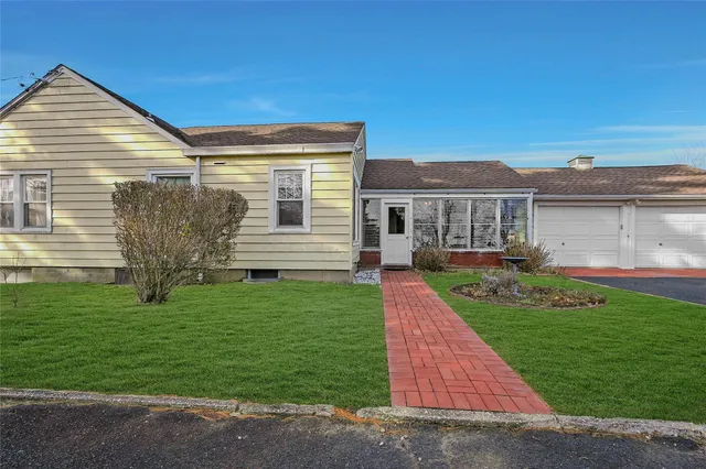 a front view of a house with a garden and yard