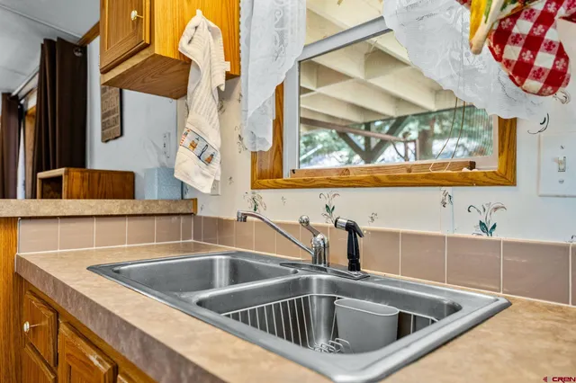 a kitchen with stainless steel appliances a dining table chairs and wooden floor