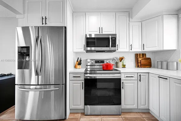 a kitchen with stainless steel appliances granite countertop a refrigerator stove and microwave