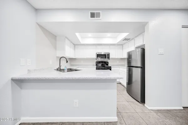 a kitchen with stainless steel appliances a sink and a refrigerator