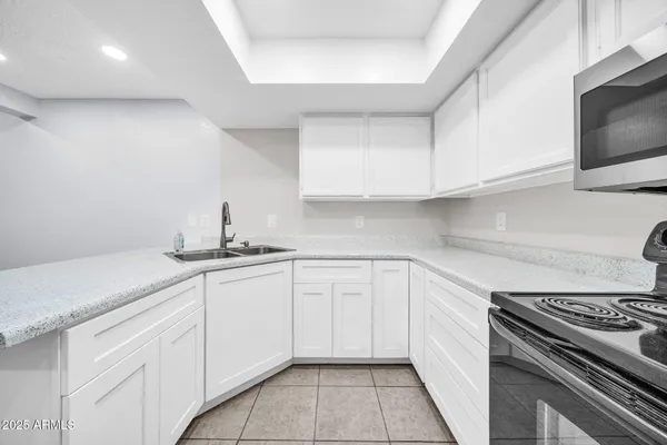 a kitchen with white cabinets and appliances