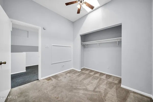 an empty room with closet and windows