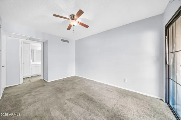 a view of a livingroom with a ceiling fan & window