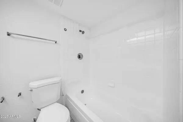 a white toilet sitting next to a shower