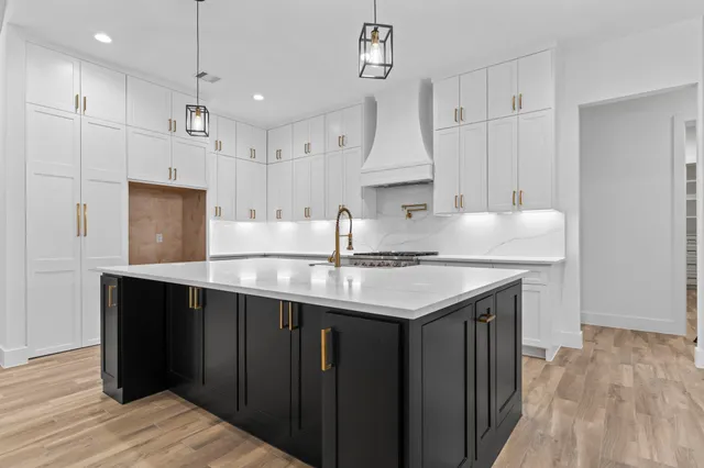 a kitchen with kitchen island a sink stainless steel appliances and cabinets