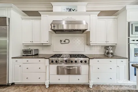 a kitchen with a table chairs appliances and cabinets