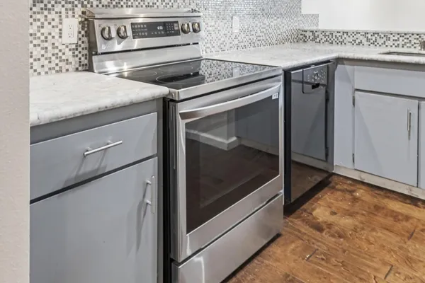 a kitchen with granite countertop cabinets stainless steel appliances and wooden floor