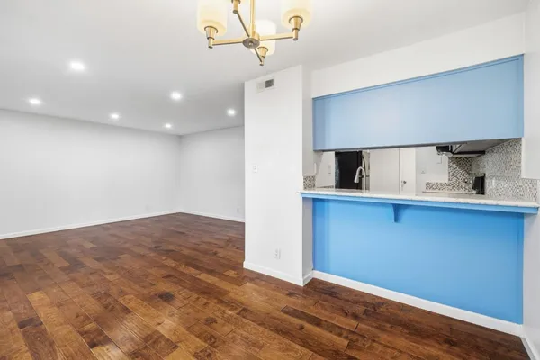a view of a small space with wooden floor and a window