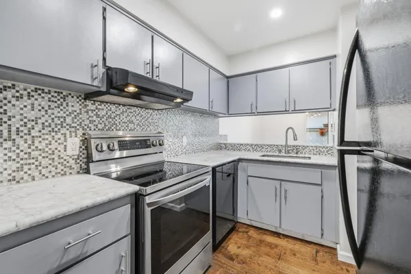 a kitchen with stainless steel appliances granite countertop a refrigerator and a sink