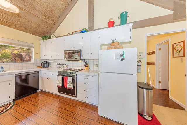 a kitchen with stainless steel appliances granite countertop a sink and wooden floors