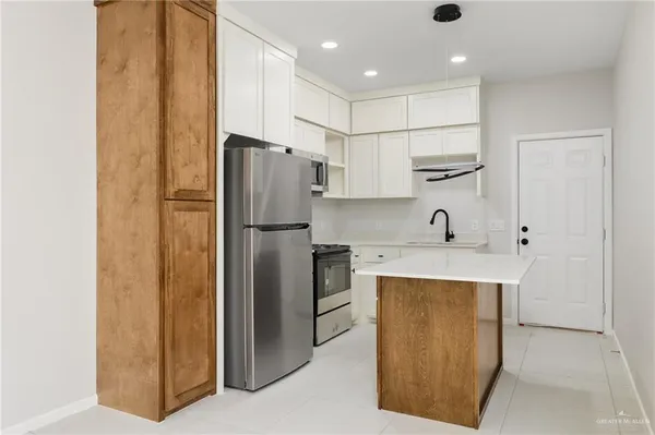 a kitchen with stainless steel appliances granite countertop a refrigerator and a stove