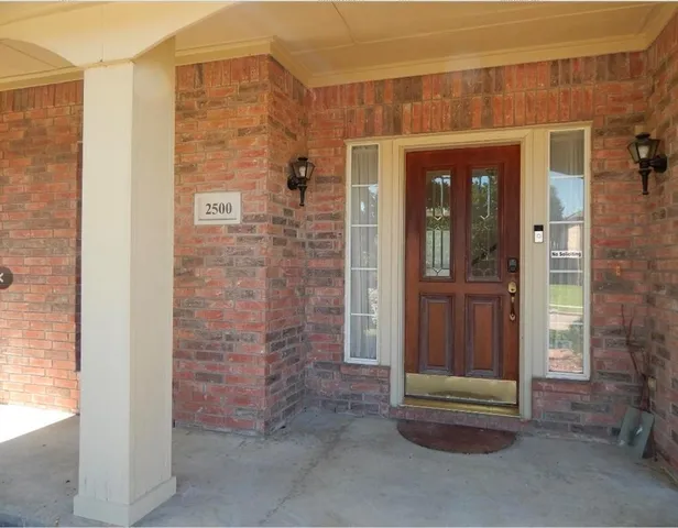 a brick building with a bench in front of door