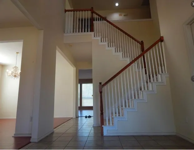 a view of staircase with railing and white walls