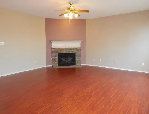 a view of empty room with wooden floor and fireplace