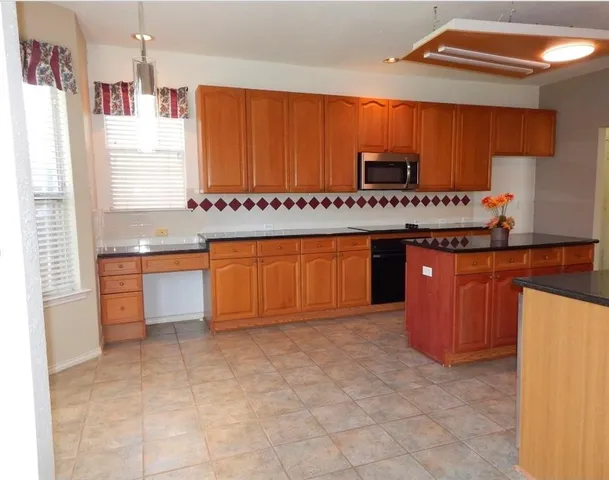 a kitchen with stainless steel appliances a sink and cabinets