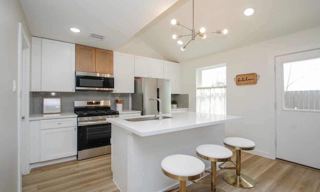 2709 Discovery Trails Conroe, TX 77301 - Photo 5 of 24 a kitchen with stainless steel appliances a sink a stove a refrigerator dining table and chairs