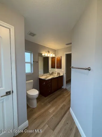 a large bathroom with a sink a toilet and a large mirror