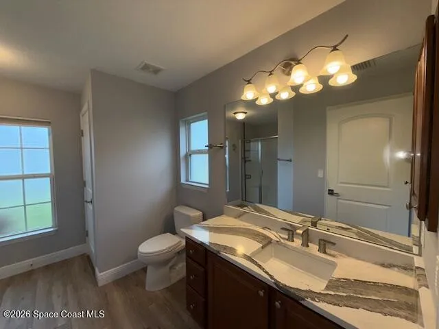 a bathroom with a granite countertop sink a toilet and a mirror