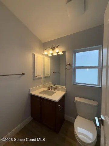 a bathroom with a toilet sink vanity granite and mirror
