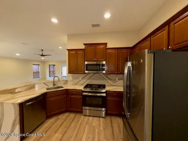 a kitchen with granite countertop a sink stove and refrigerator
