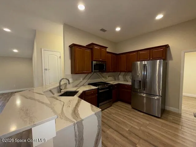 a kitchen with a refrigerator sink and wooden cabinets