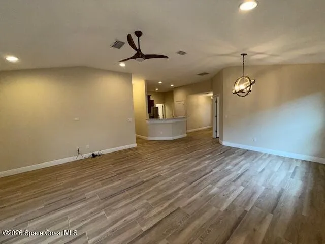 a view of a room with wooden floor and ceiling fan