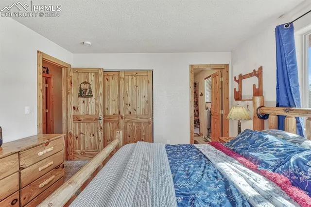 a bedroom with a bed and a large mirror on the dresser