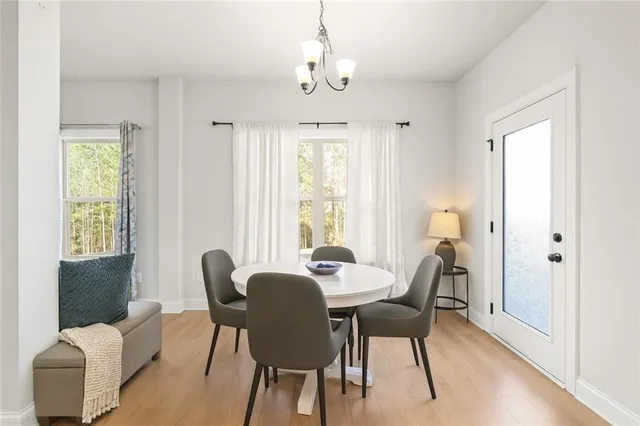 a dining room with furniture a chandelier and wooden floor