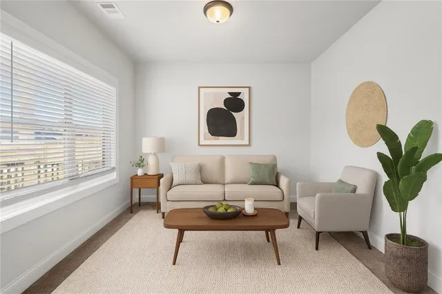 a living room with furniture a potted plant and a large window