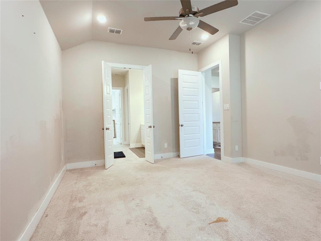 1304 Caprock Drive Forney, TX 75126 - Photo 6 of 15 Unfurnished bedroom with light carpet, ensuite bath, ceiling fan, and lofted ceiling